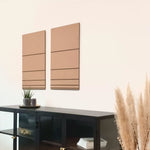 Frau hängt hochwertiges 3D Wandbild in der Farbe beige und schwarz aus Filz und Holz im Wohnzimmer auf